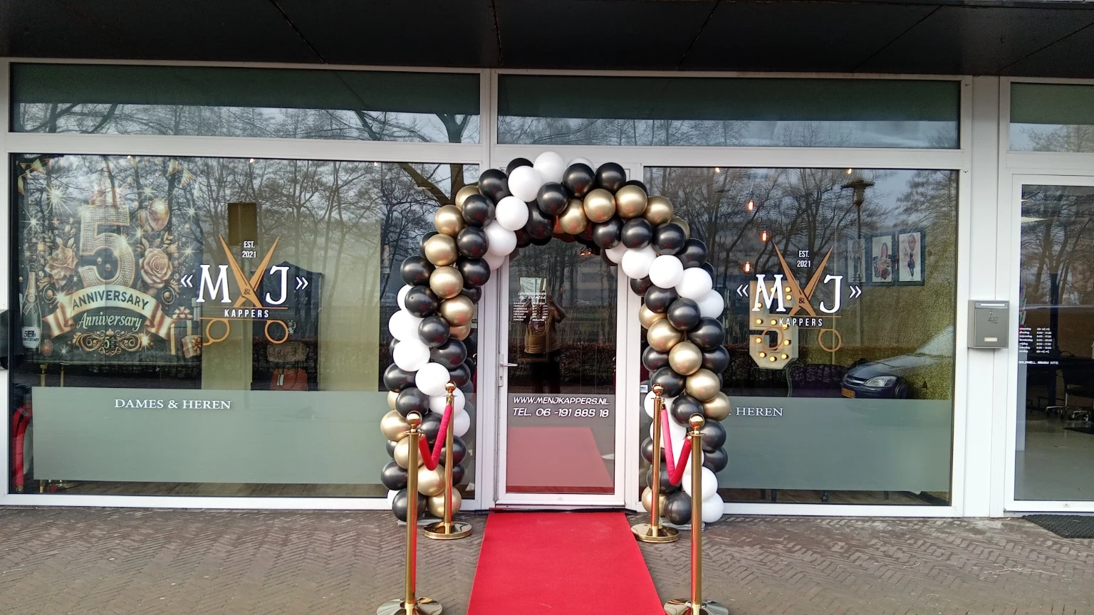 Ballonboog voor de ingang van een kapsalon met rode loper