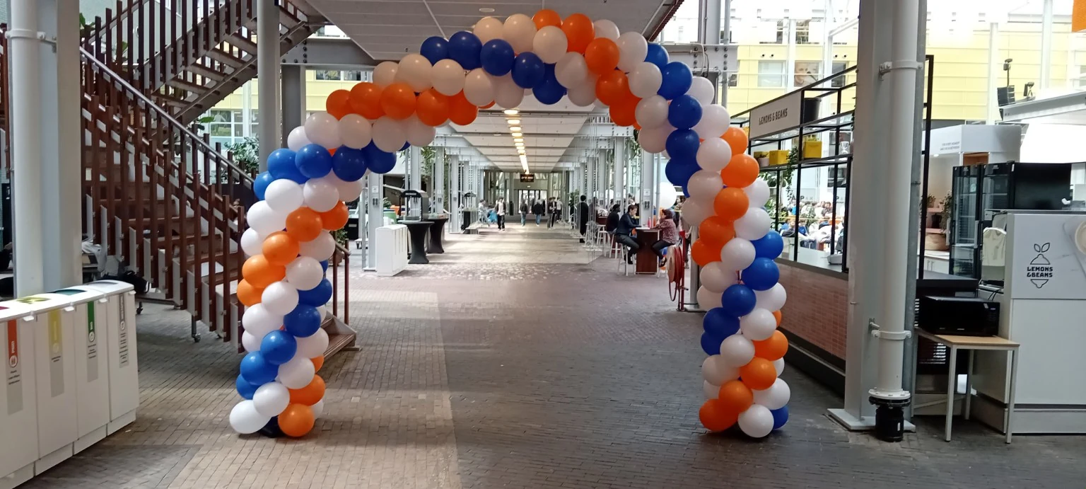 Grote ballonboog in blauw, wit en oranje in een overdekte passage