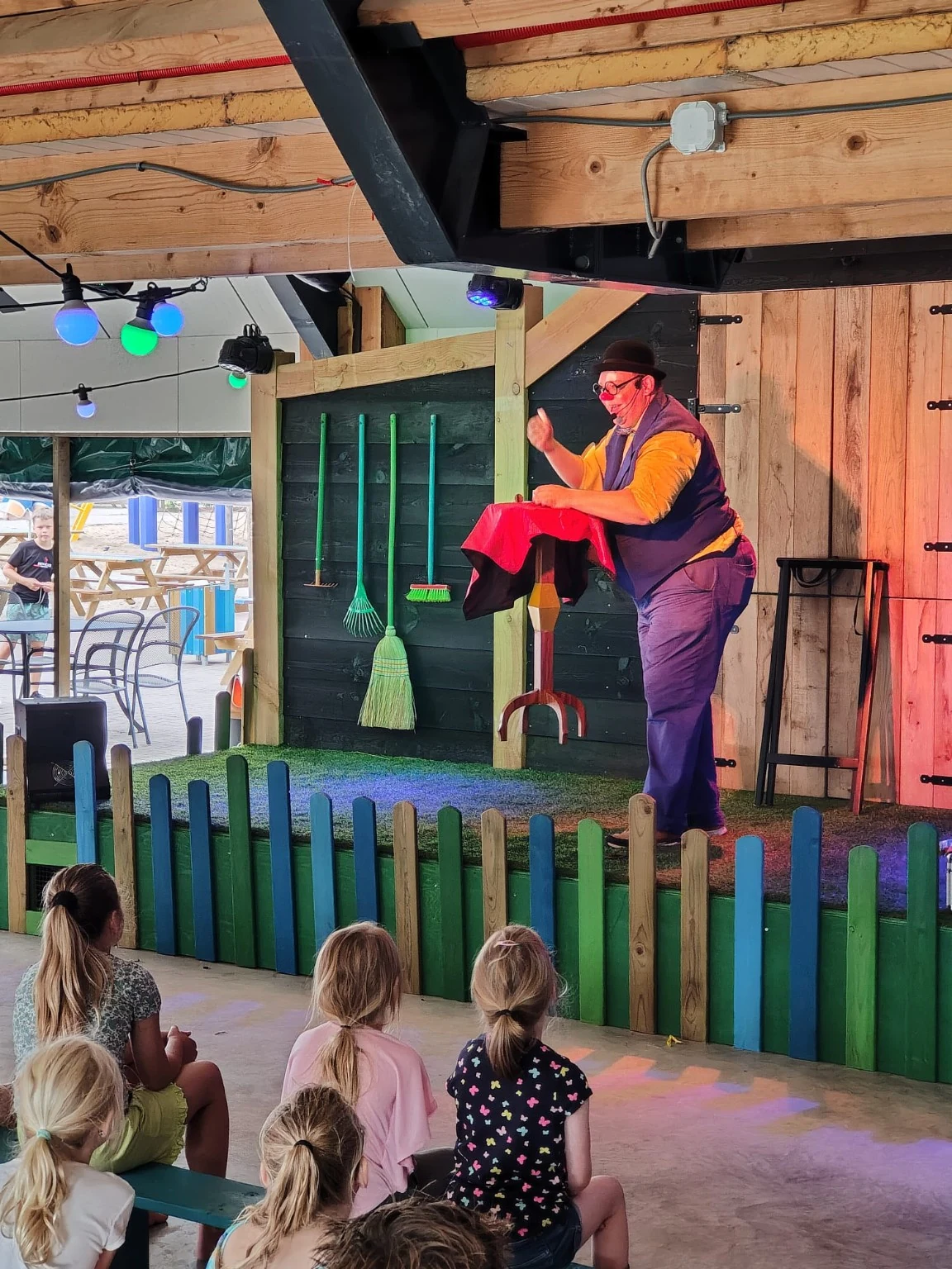 Clown Spekkie speelt een show voor kinderen op een podium