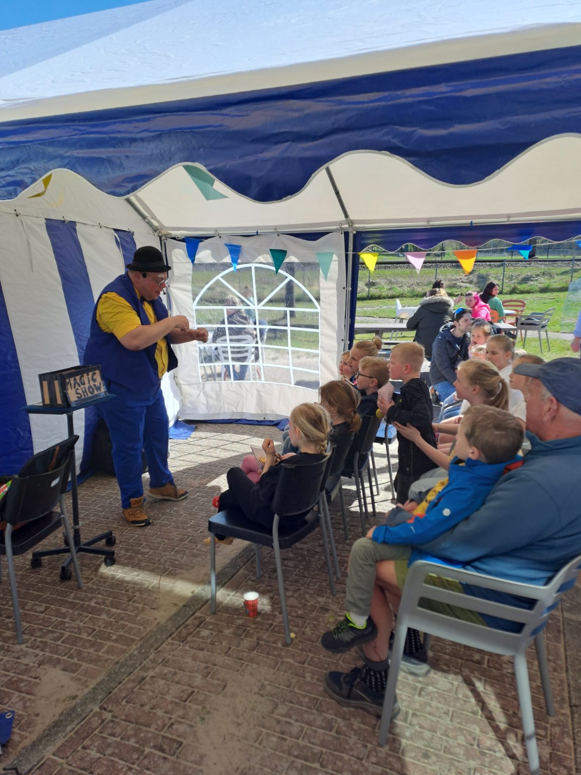 Clown Spekkie tijdens een goochelshow bij de opening van het speeltuinseizoen in Hattemerbroek
